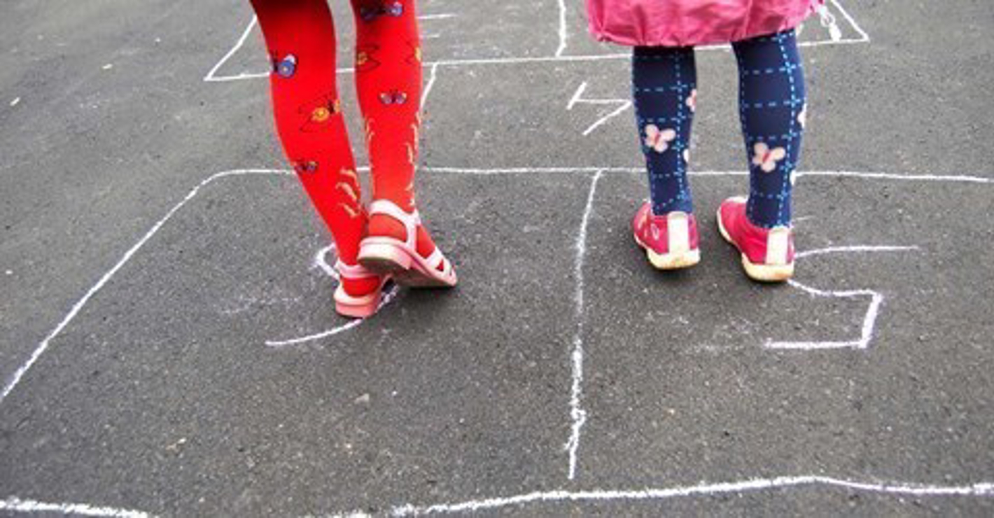 Ben i hinkeruder, der er tegnet med kridt på asfalt.