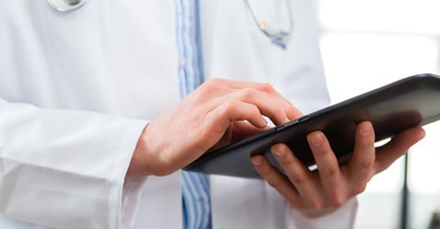 Læge med computertablet i hånden.