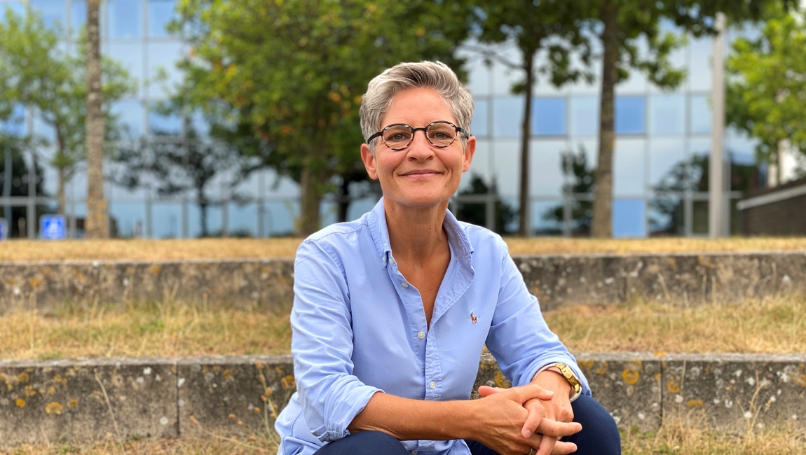 Borgerrådgiver Tina H. Jepsen sidder på en trappe ved rådhuset i Greve Kommune.
