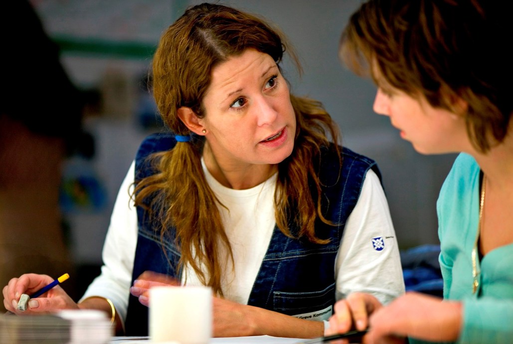 To damer sidder ved et bord.