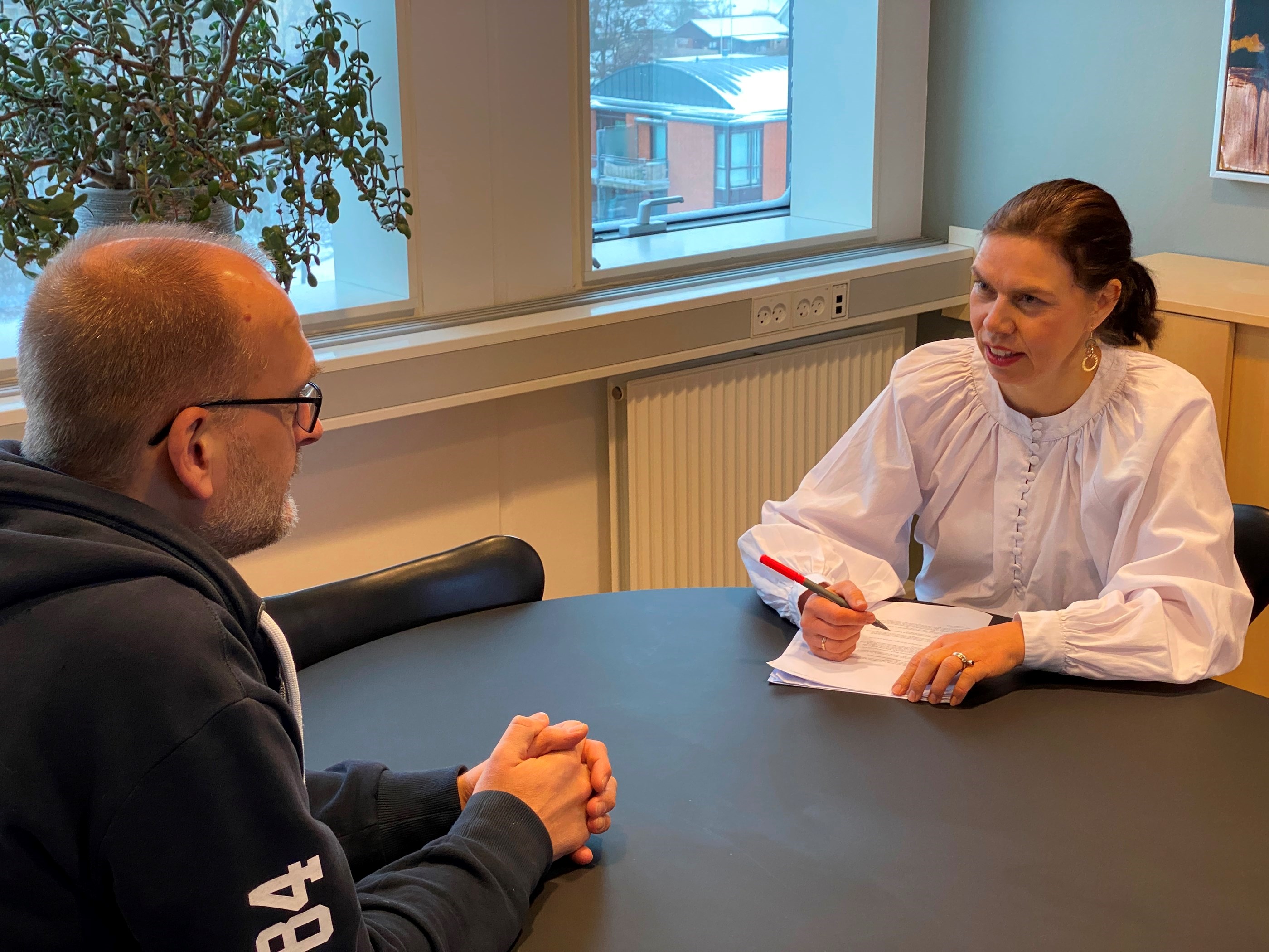 To personer i samtale ved bord.