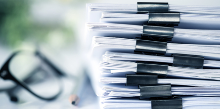 Briller og en bunke dokumenter