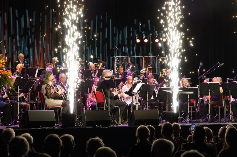 Orkester på scene med fyrværkeri i forgrunden