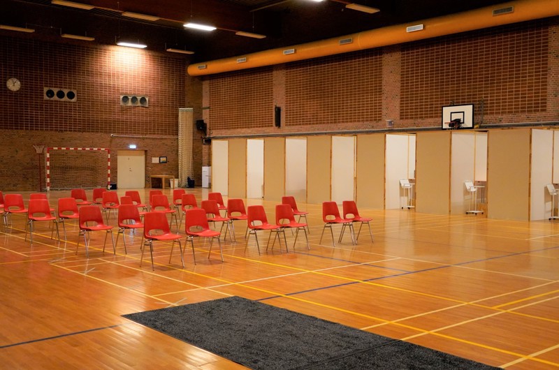 Røde stole på række i idrætshallen ved Greve Videncenter