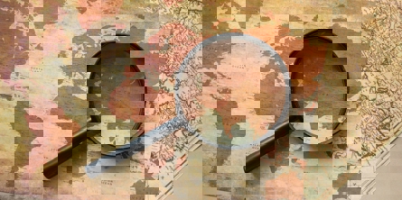 Gammelt verdenskort med et forstørrelsesglas ovenpå