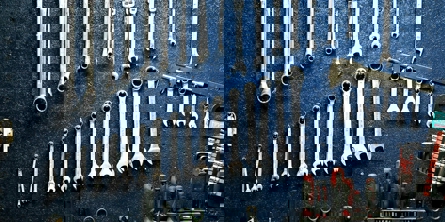 Ringgaffelnøgler i forskellige størrelser der ligger i orden, med andet værktøj i bunden af billedet