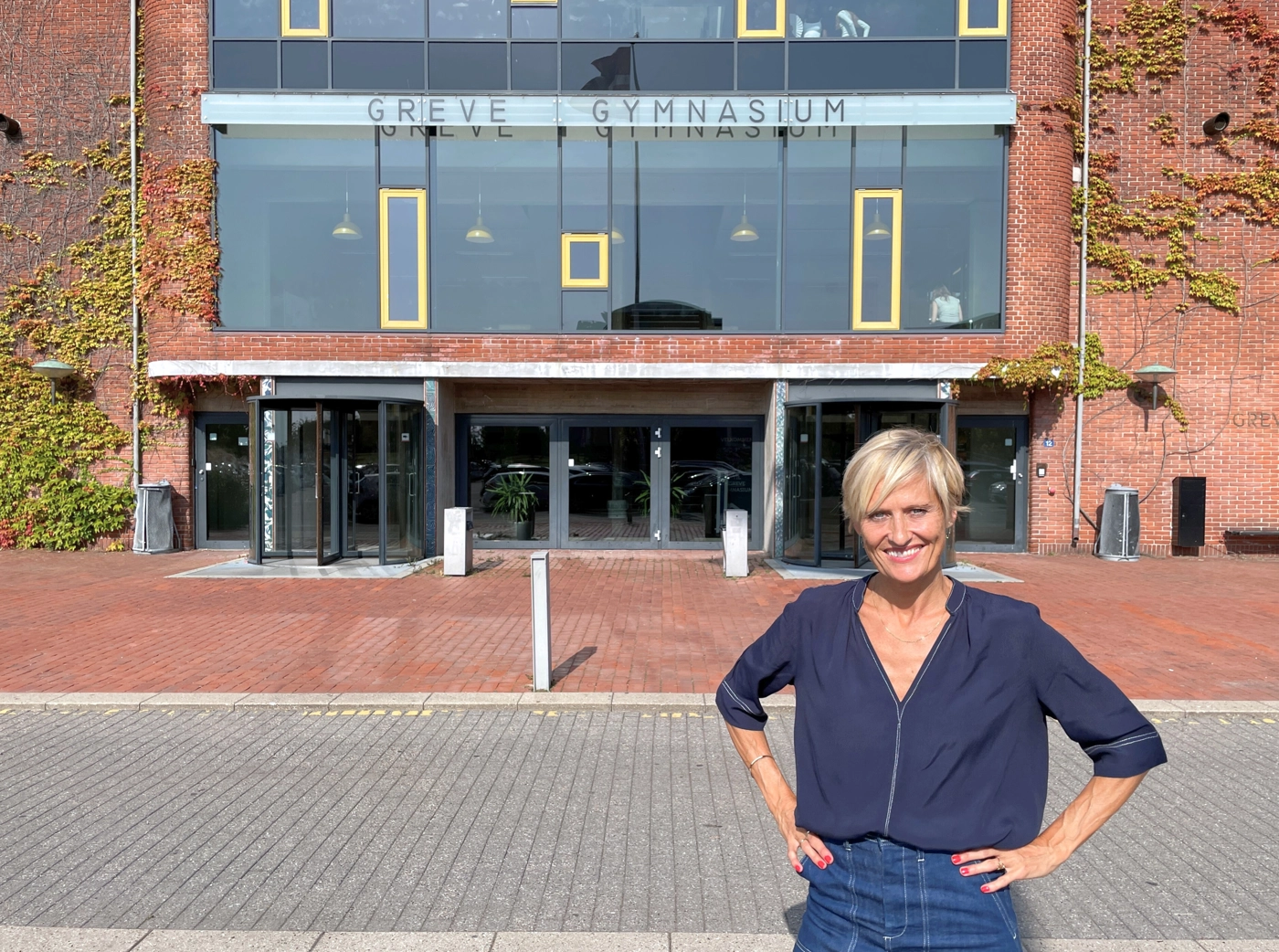 Kvinde der står foran Greve Gymnasium